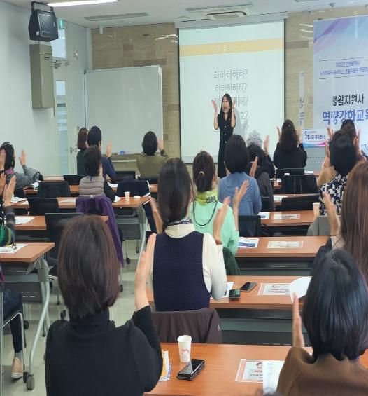 강의실에서 참여자와 함께 웃음 활동을 하는 고아라 강사