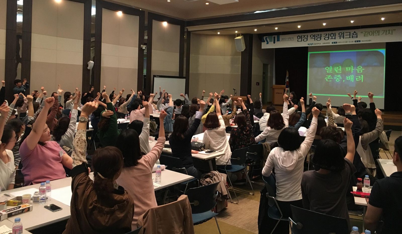 대강당을 가득 채운 청중이 손을 들고 함께 웃는 고아라 웃음치료 특강